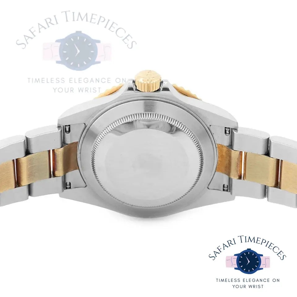 Close-up of a silver and gold watch with 'Safari Timepieces' branding.