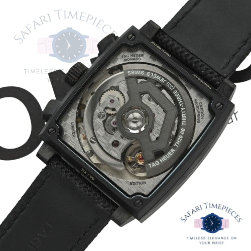 Close-up of a Tag Heuer Monaco watch with visible movement on a white background